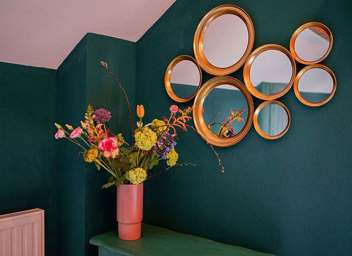 Lichte woonkamer in Vakantiehuis in Well, Noord Limburg met groot raam en gezellige sfeer.