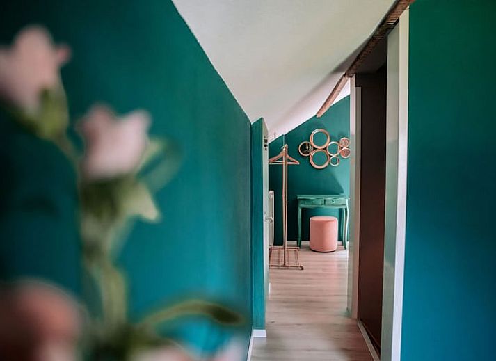 Lichte woonkamer in Vakantiehuis in Well, Noord Limburg met groot raam en gezellige sfeer.