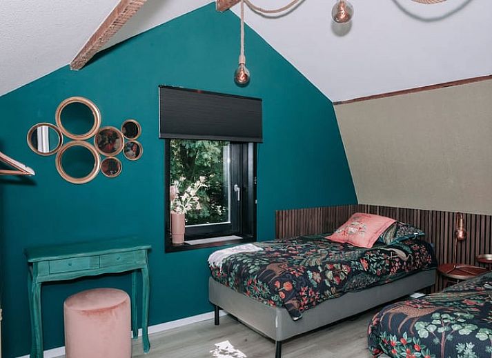 Lichte woonkamer in Vakantiehuis in Well, Noord Limburg met groot raam en gezellige sfeer.