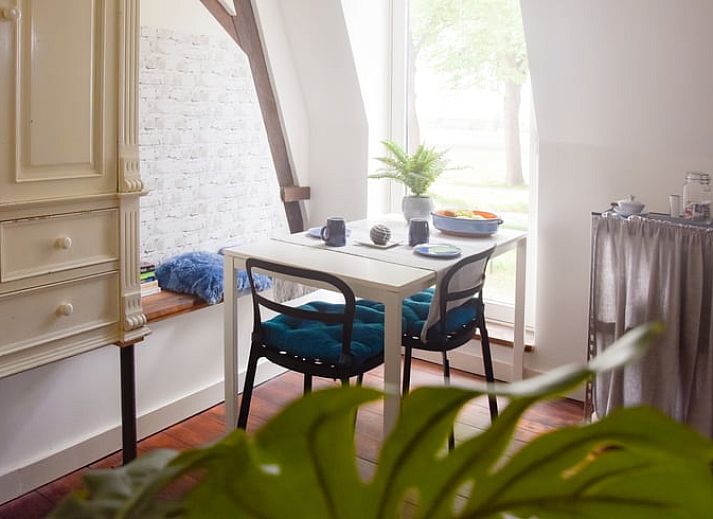 Gezellige eetruimte in Huisje in Well, vakantiehuis in Noord Limburg, met uitzicht op de natuur en vers fruit.