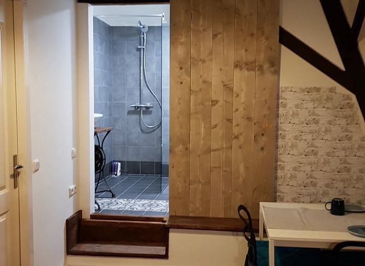 Comfortabele woonkamer in Huisje in Well, vakantiehuis in Well, Limburg, met gezellige zithoek en decoratieve planten.