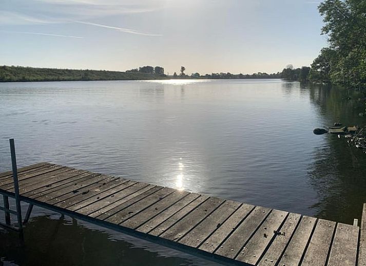 Stimmungsvoll beleuchtetes Landhaus in Geijsteren, Nord-Limburg, umgeben von Baeumen bei Sonnenuntergang.