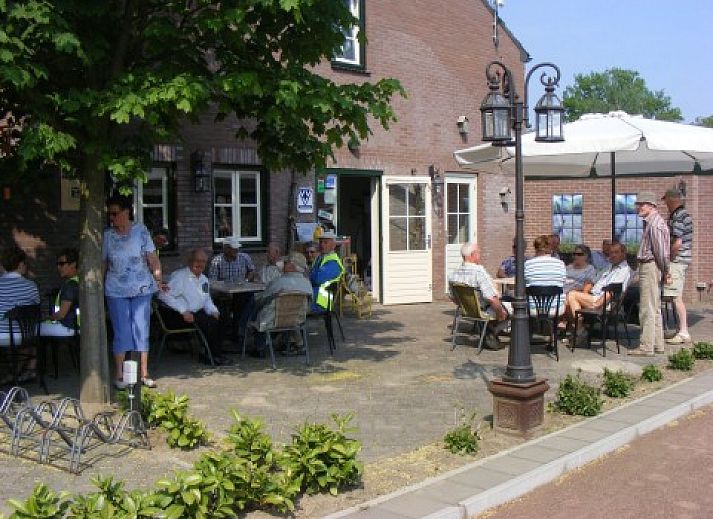 Terras bij Appartement Groen, Blauw of Rood in Horst, Noord Limburg met gezellige zitjes en schaduwrijke bomen.