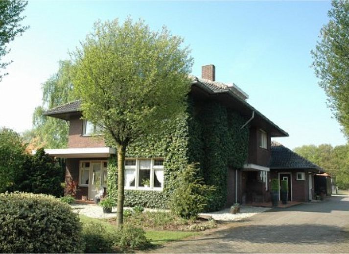 Eingang zur Ferienvilla Hubertushof in Horst, Nord-Limburg, umgeben von grnen Bumen und einer ruhigen Umgebung.