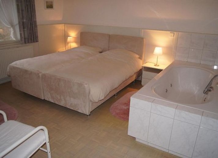 Gerumiges Schlafzimmer mit groem Bett in der Ferienvilla Hubertushof, Horst, Nord-Limburg, mit viel Tageslicht und eleganten Vorhngen.