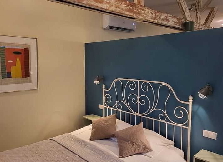 Buitenzwembad bij Vakantiehuis in Venlo, Noord Limburg met ligstoelen en kleurrijke muurschildering.