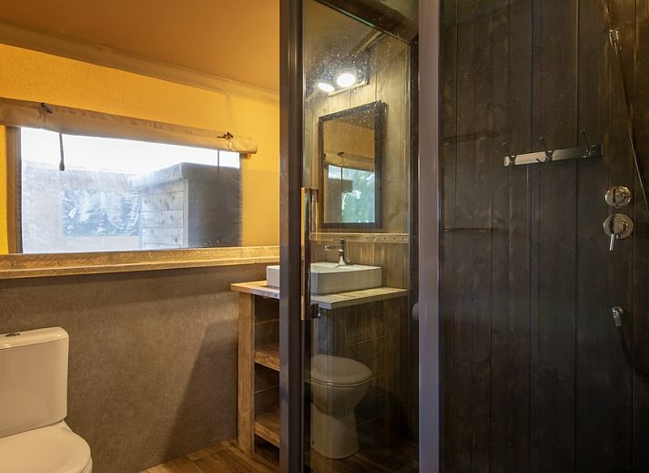 Gemuetlicher Innenbereich des Safari-Zeltes 6B in Arcen, Nord-Limburg, mit Holzmoebeln und modernen Annehmlichkeiten fuer ein komfortables Glamping-Erlebnis.