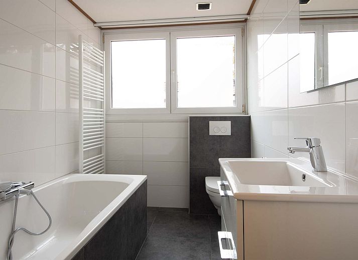 Gezellige woonkamer in de Vrijstaande woning in Arcen, Noord Limburg, met comfortabele banken en uitzicht op de groene tuin.