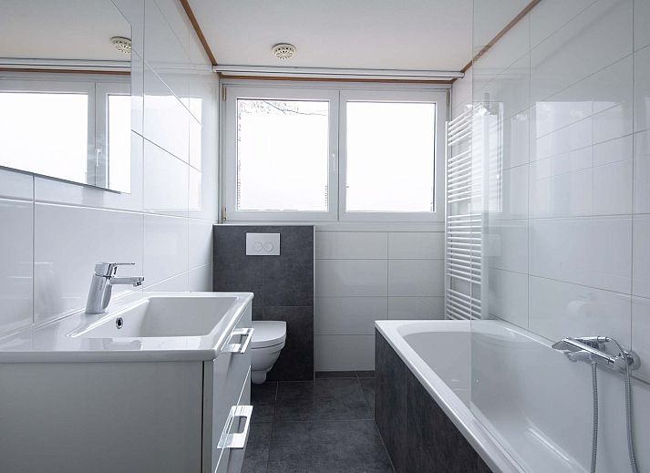 Gezellige woonkamer in de Vrijstaande woning in Arcen, Noord Limburg, met comfortabele banken en uitzicht op de groene tuin.