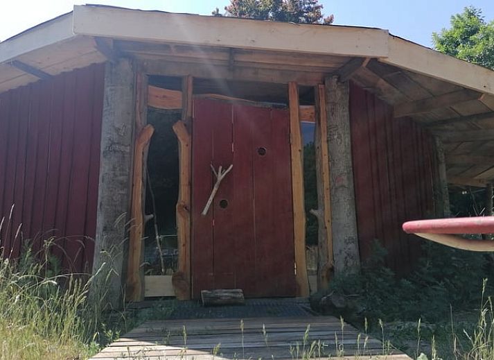 Rustiek Vakantiehuisje in Afferden, Noord Limburg, met houten veranda en rode gevel.