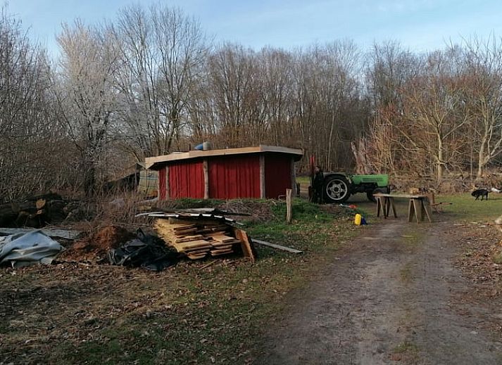 Rustiek Vakantiehuisje in Afferden, Noord Limburg, met houten veranda en rode gevel.