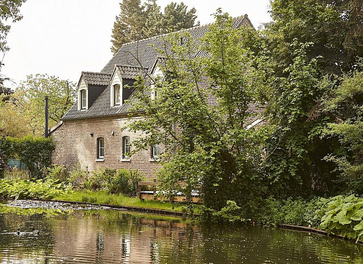 Restful garden at vacation home L185 in Baarlo, North Limburg, surrounded by blooming flowers and green nature.