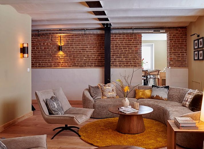 Gemuetliches Wohnzimmer im Ferienhaus in Baarlo, Nord-Limburg mit stilvoller Einrichtung und bequemem Ecksofa.