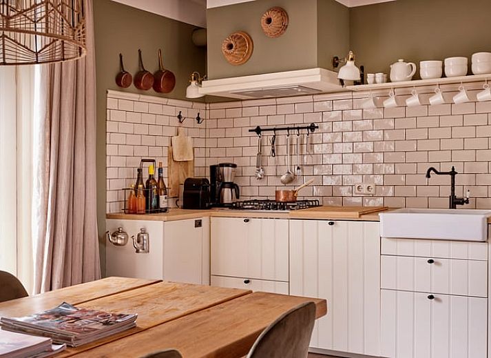 Lichte woonkamer in vakantiehuis Huisje in Baarlo, Limburg, met ruime ramen en warme kleuren.