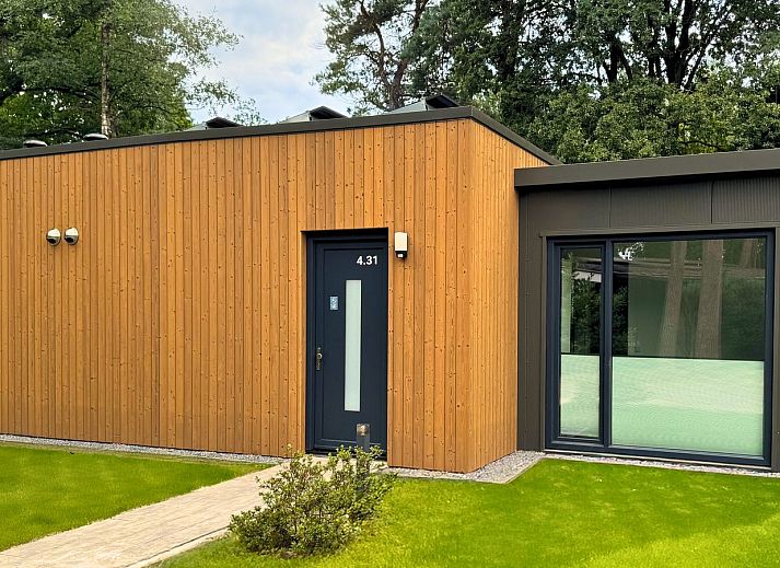 Geniet van de serene Bos Lodge in Maasbree, Noord Limburg, met een ruim terras en groene omgeving voor acht personen.