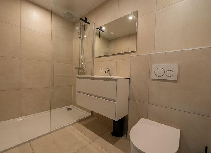 Luxurioese Einrichtung der Bos Villa DeLuxe XL in Maasbree, Nord-Limburg, Ferienhaus mit modernem Wohnzimmer und Blick auf die Terrasse.