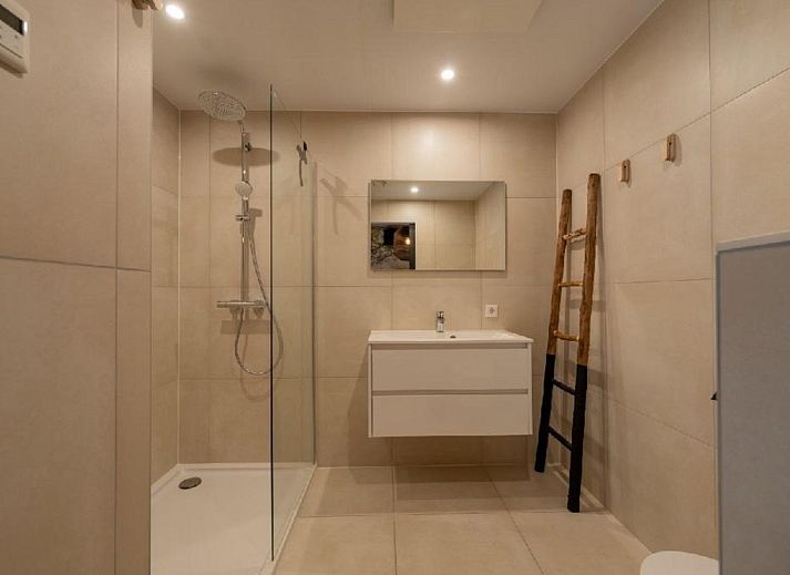 Luxurioese Einrichtung der Bos Villa DeLuxe XL in Maasbree, Nord-Limburg, Ferienhaus mit modernem Wohnzimmer und Blick auf die Terrasse.