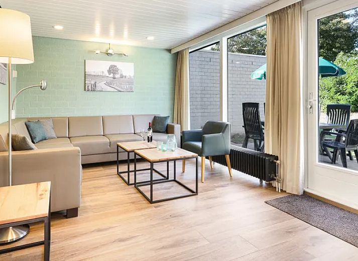 Gezellige woonkamer in De Lommerbergen 6-persoons bungalow 6C in Reuver, Noord Limburg met open haard en ruime zitplek.