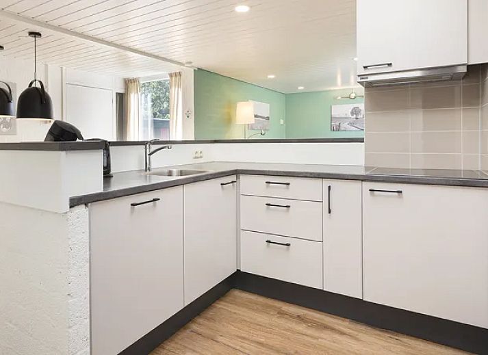 Gezellige woonkamer in De Lommerbergen 6-persoons bungalow 6C in Reuver, Noord Limburg met open haard en ruime zitplek.