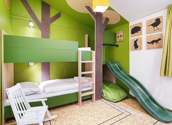 Cozy living room with fireplace in De Lommerbergen 4-person children's bungalow, Reuver, North Limburg. Perfect for family time.