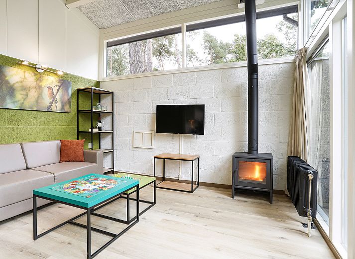 Cozy living room with fireplace in De Lommerbergen 4-person children's bungalow, Reuver, North Limburg. Perfect for family time.