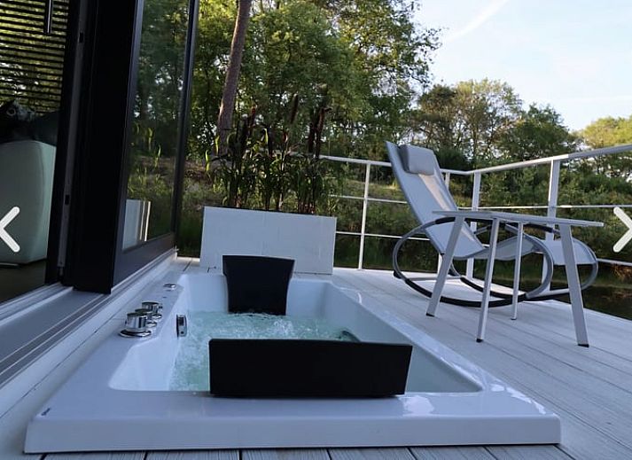 Rustikaler Strand in der Naehe des Ferienhauses in Merselo, Nord-Limburg, mit Liegestuehlen und einem Boot.