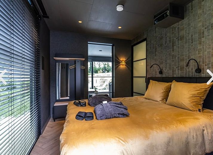 Rustikaler Strand in der Naehe des Ferienhauses in Merselo, Nord-Limburg, mit Liegestuehlen und einem Boot.