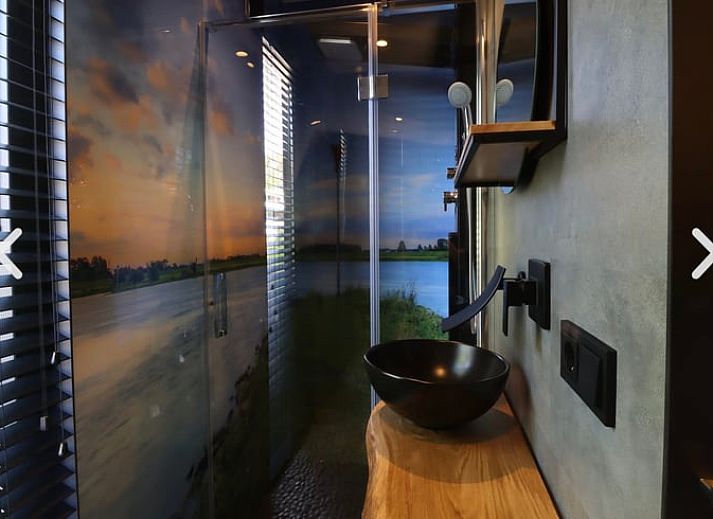 Rustikaler Strand in der Naehe des Ferienhauses in Merselo, Nord-Limburg, mit Liegestuehlen und einem Boot.