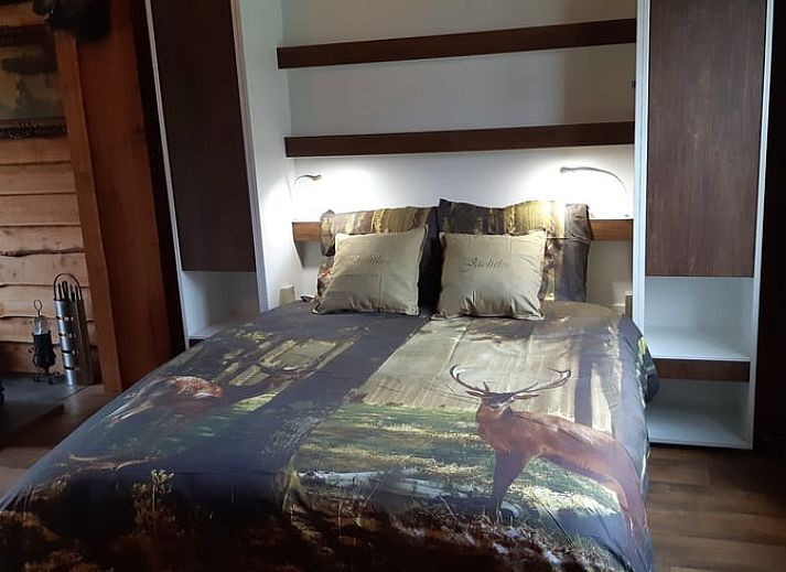 Hunting-themed decor in Holiday home in Sevenum, North Limburg, with deer antlers and rifle.