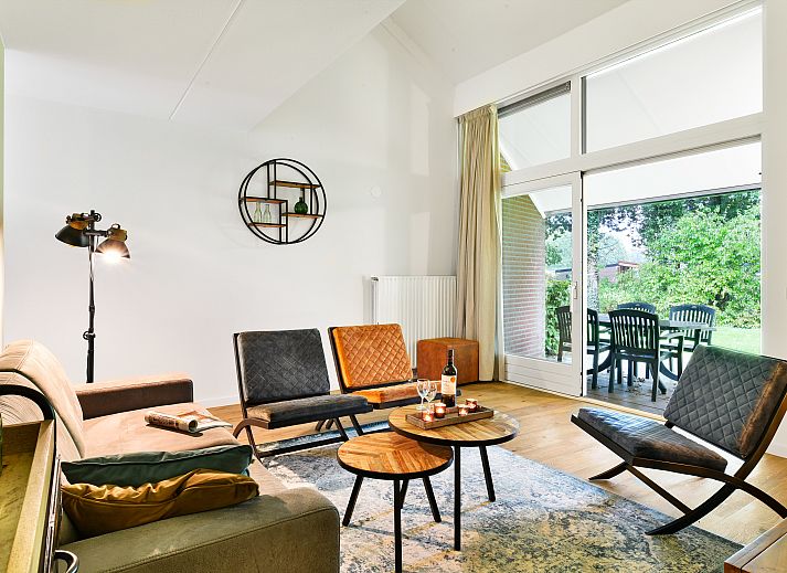 Gezellige woonkamer in Domein De Schatberg 6-persoons woning, Sevenum, met uitzicht op het terras en groene omgeving.
