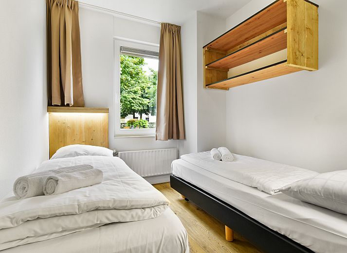 Gezellige woonkamer in Domein De Schatberg 6-persoons woning, Sevenum, met uitzicht op het terras en groene omgeving.