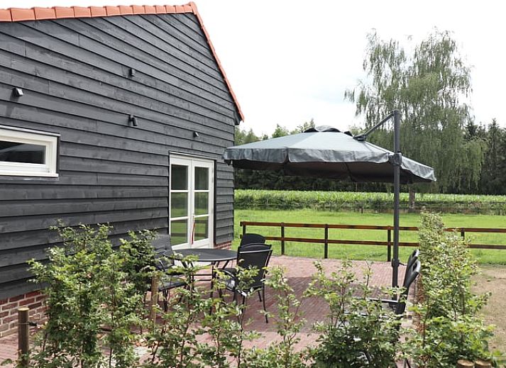 Aussenansicht des Ferienhauses in Baexem, Nord-Limburg mit gruener Umgebung.