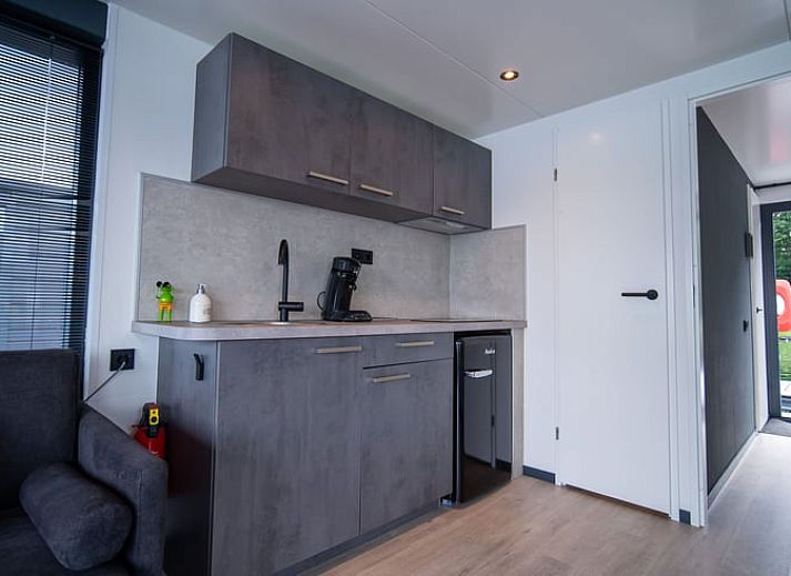 Vakantiehuisje in Middelaar, Noord Limburg, drijvend vakantiehuis met terras aan het water, omgeven door natuur en rust.