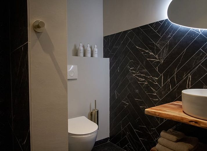 Gezellige veranda van Vakantiehuis in Griendtsveen, Noord Limburg, met uitzicht op groene natuur en comfortabele zitjes.