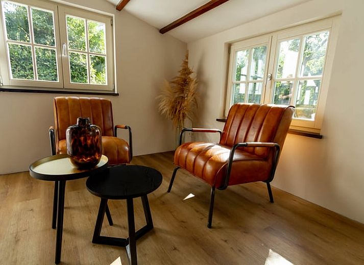 Gezellige slaapkamer in Vakantiehuisje in Griendtsveen, Noord Limburg met houten balken en comfortabele stoelen voor een ontspannen verblijf.