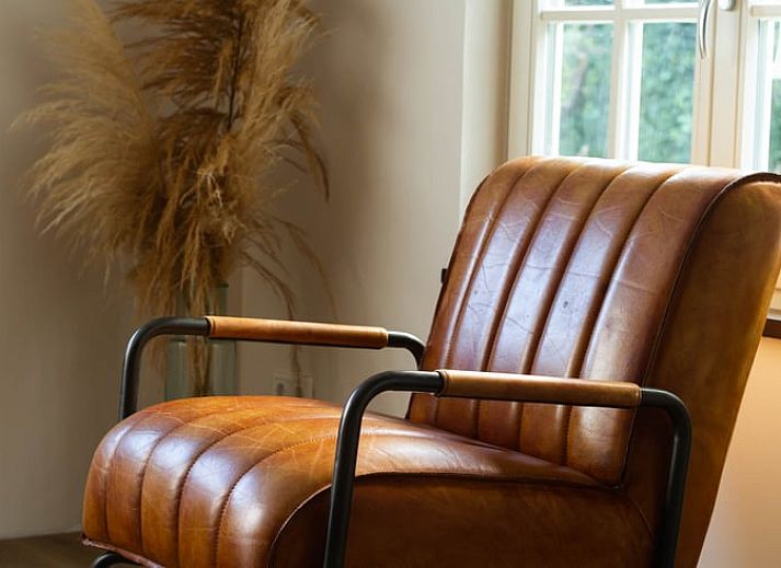 Gezellige slaapkamer in Vakantiehuisje in Griendtsveen, Noord Limburg met houten balken en comfortabele stoelen voor een ontspannen verblijf.