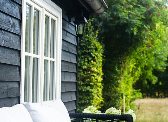 Gezellige slaapkamer in Vakantiehuisje in Griendtsveen, Noord Limburg met houten balken en comfortabele stoelen voor een ontspannen verblijf.