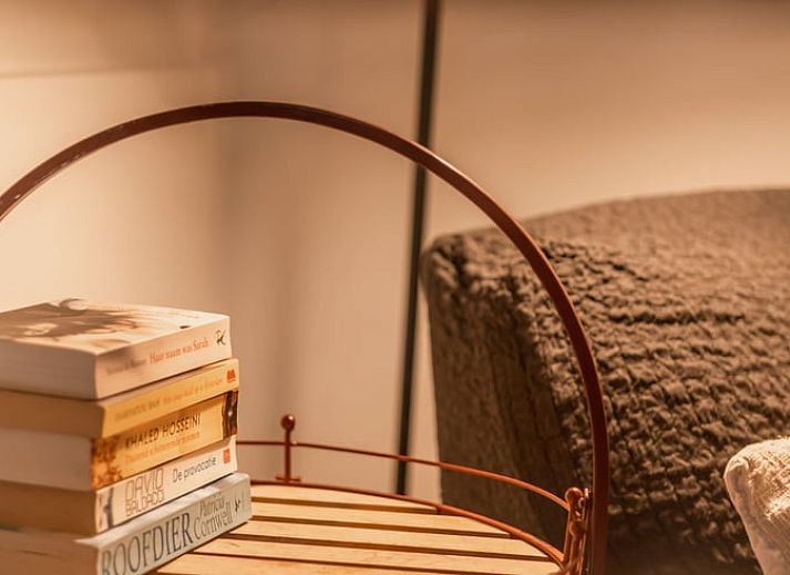Cozy living room of Holiday Home in Maastricht, South Limburg with comfortable sofas and wooden staircase.