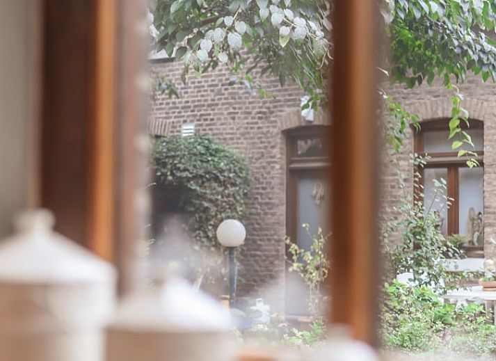 Nice reading corner in Holiday Home in Maastricht, South Limburg with books and a comfortable chair.