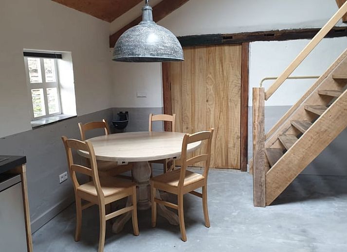 Rustic terrace at cottage in Heijenrath, Limburg. Enjoy the outdoors at a wooden table overlooking green surroundings.