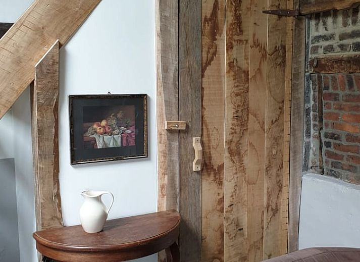 Rustic terrace at cottage in Heijenrath, Limburg. Enjoy the outdoors at a wooden table overlooking green surroundings.