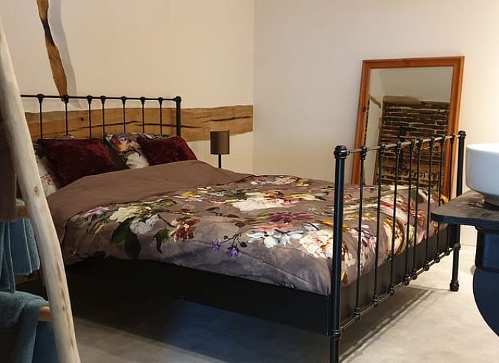 Rustic terrace at cottage in Heijenrath, Limburg. Enjoy the outdoors at a wooden table overlooking green surroundings.