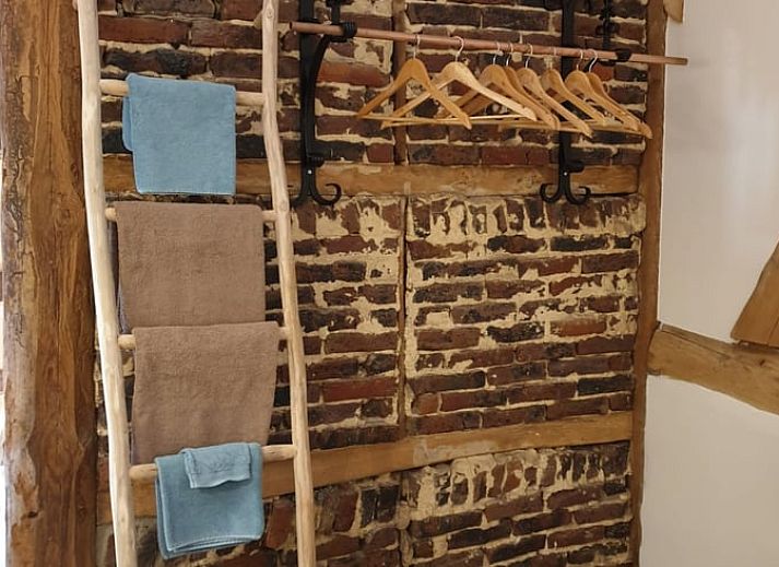 Rustic terrace at cottage in Heijenrath, Limburg. Enjoy the outdoors at a wooden table overlooking green surroundings.