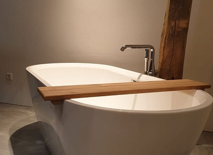 Rustic terrace at cottage in Heijenrath, Limburg. Enjoy the outdoors at a wooden table overlooking green surroundings.