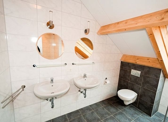 Gezellige woonkamer in Vakantiehuis in Mechelen, Zuid Limburg met comfortabele banken en uitzicht op de groene omgeving.