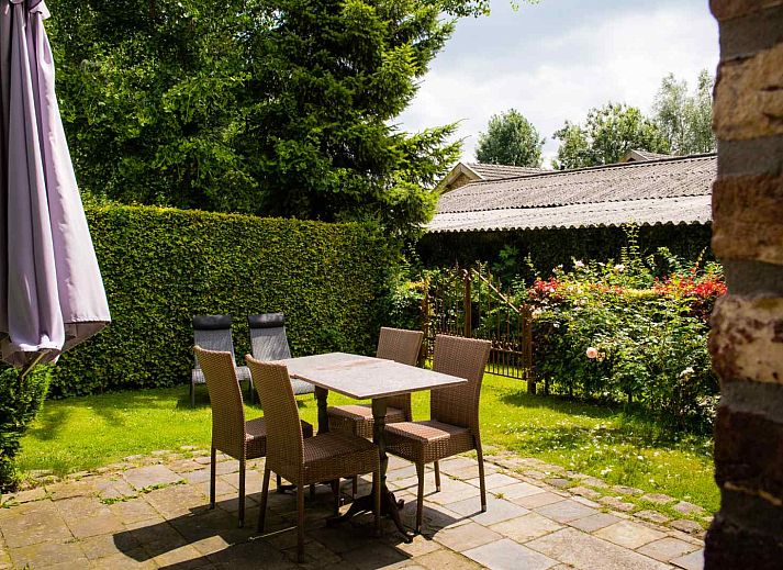 Gemuetlicher Innenhof des Ferienhauses L267 in Mechelen, Suedlimburg, mit bluehenden Pflanzen und rustikalem Charme.