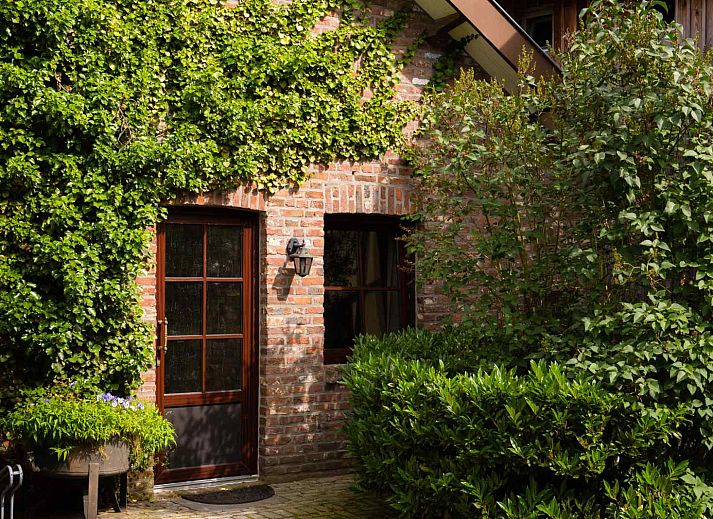 Sonnige Terrasse des Ferienhauses L267 in Mechelen, Suedlimburg, umgeben von viel Gruen und bequemen Gartenmoebeln.