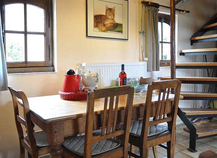 Esszimmer in L302 Ferienhaus Mechelen Suedlimburg mit Holztisch und Katzenbild.