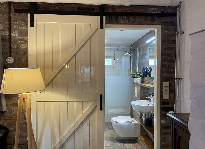 Eingang zum Ferienhaus L302 Mechelen Suedlimburg mit Holztuer und Willkommensschild.