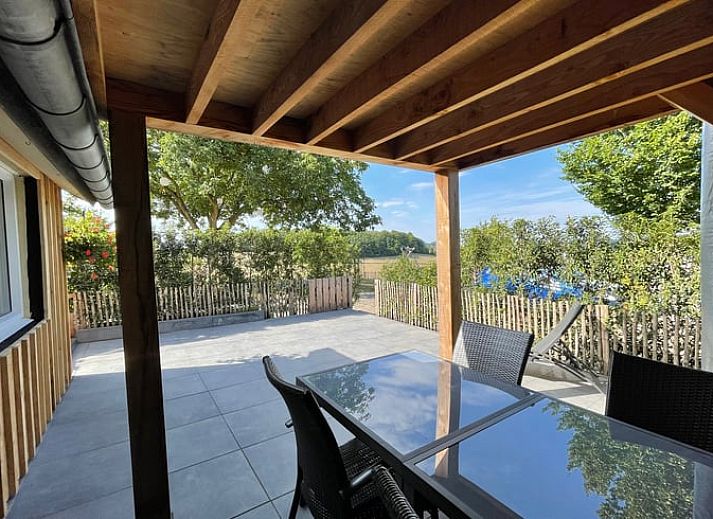 Enjoy the sunny veranda at Huisje in Schin op Geul, a charming vacation home in South Limburg.